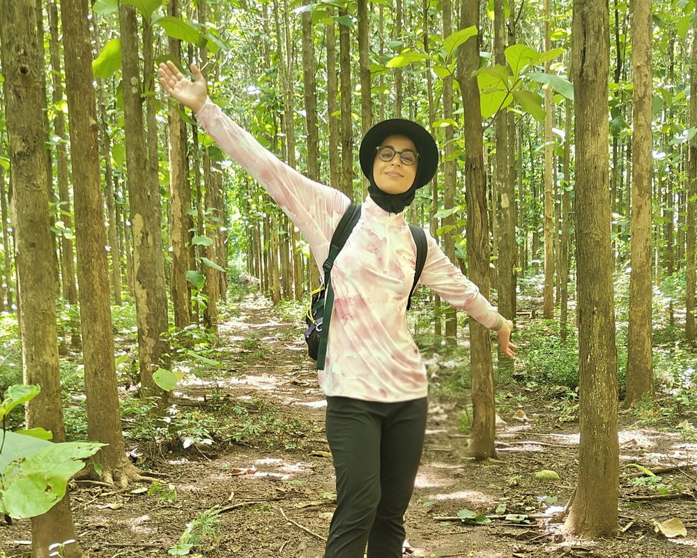 Women standing in a forest with trees and greenery around, hiking in natural fibre activewear 