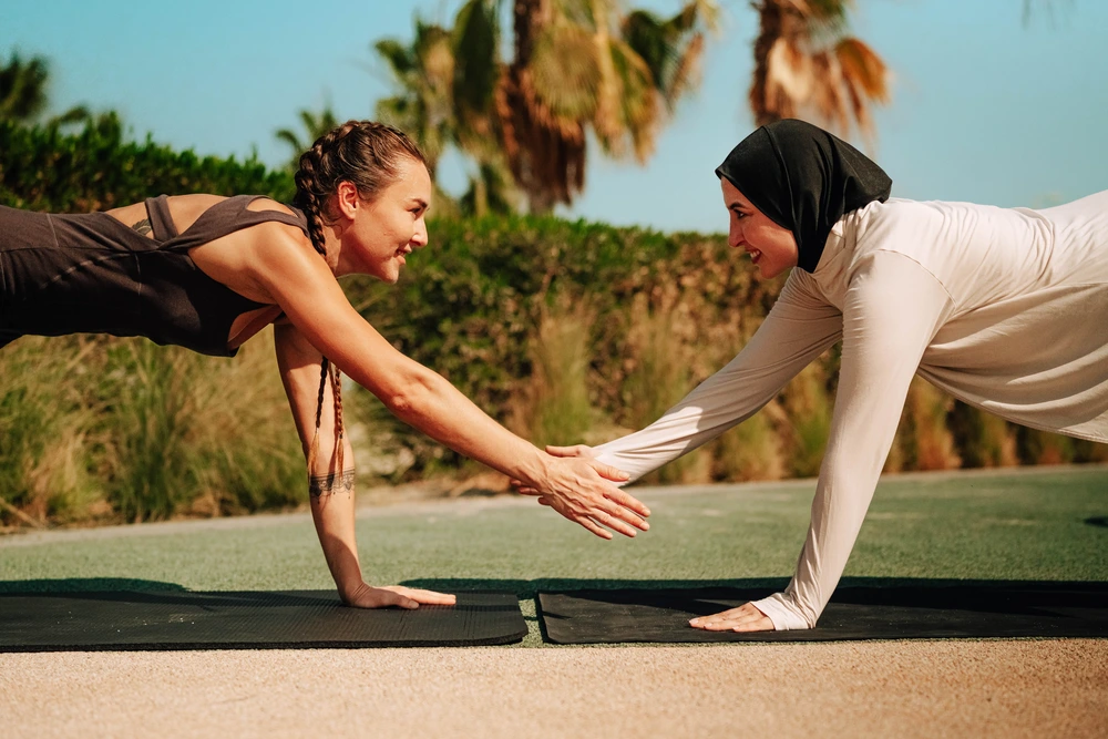 Woman performing dynamic handstand freeze move on urban rooftop with city buildings, showcasing strength, balance and athletic performance